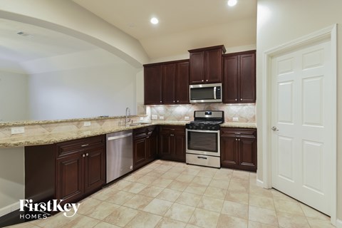 A kitchen with brown cabinets and a white door.