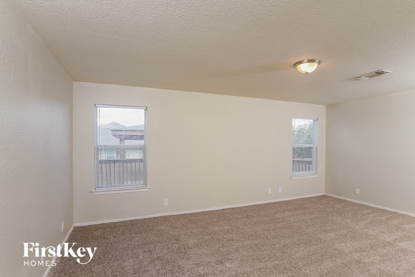 an empty living room with two windows