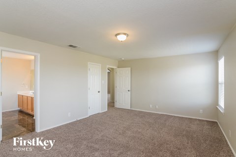 a living room with carpet and a door to a bathroom