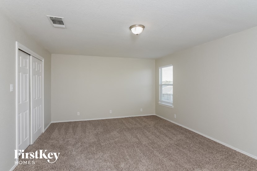 an empty living room with carpet and a window