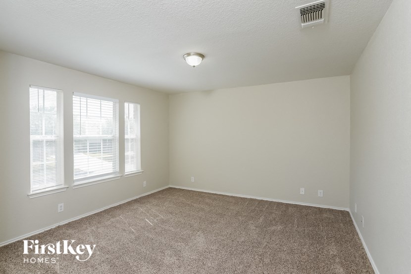 a bedroom with a carpeted floor and two windows