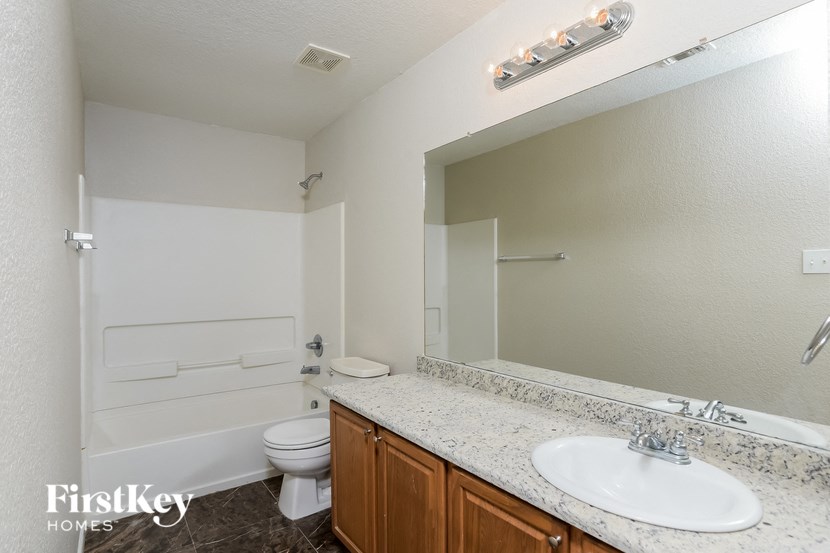 a bathroom with a sink toilet and a mirror
