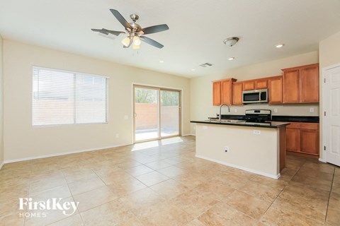 A kitchen with a fan on the ceiling and a microwave on the counter.