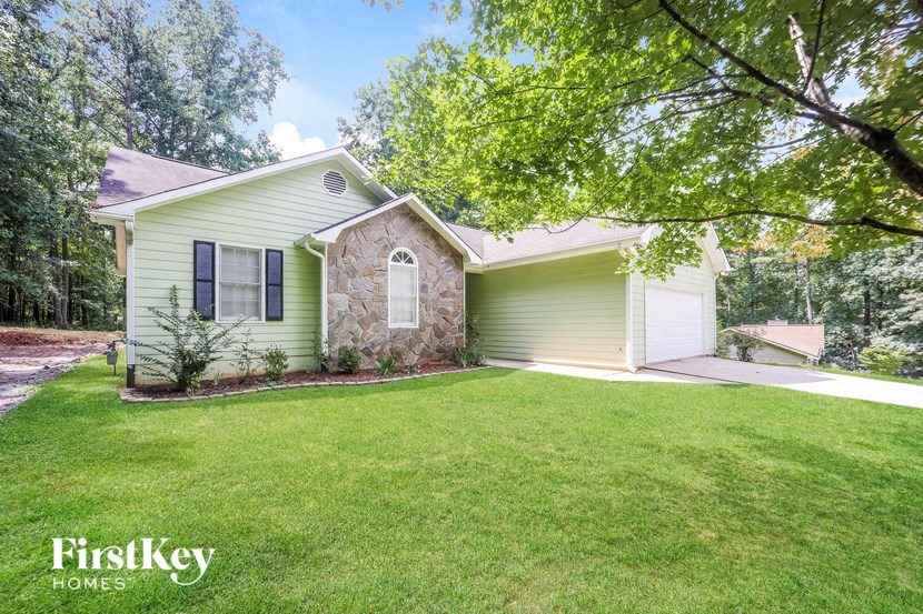 a green house with a lawn and a tree