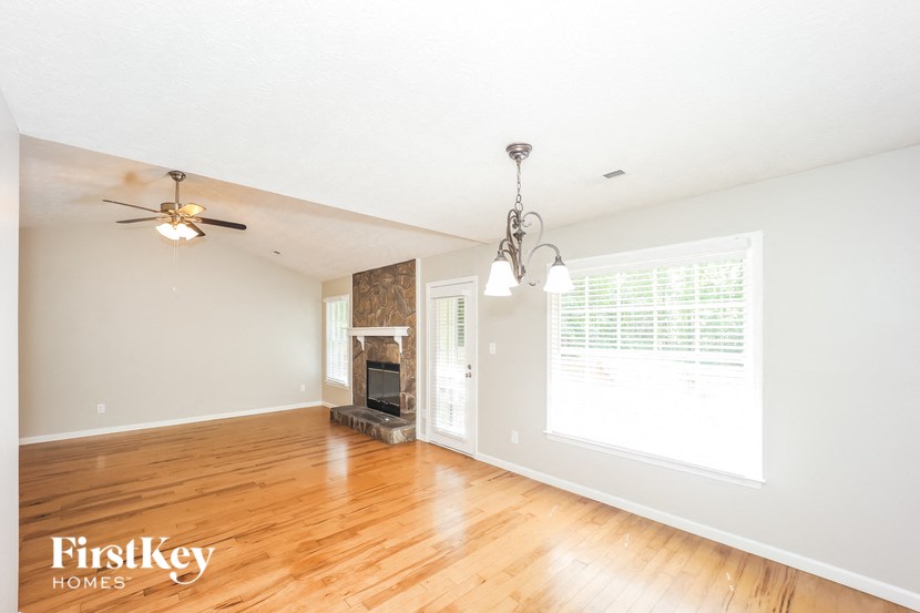 an empty living room with wood floors and a fireplace