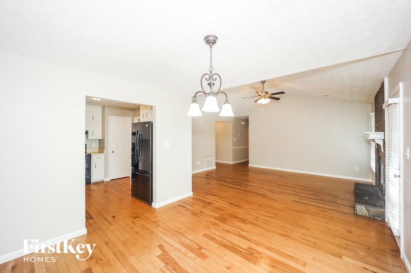 the living room and dining room with hardwood flooring and a ceiling fan