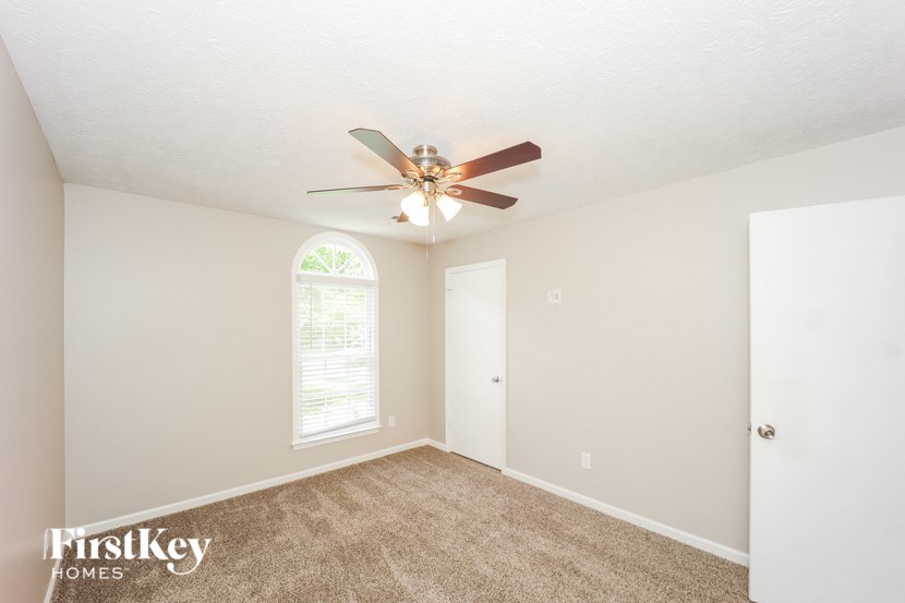 a bedroom with carpet and a ceiling fan