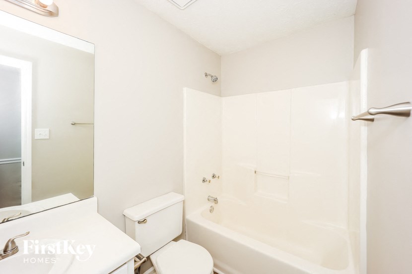 a white bathroom with a tub and a toilet and a sink
