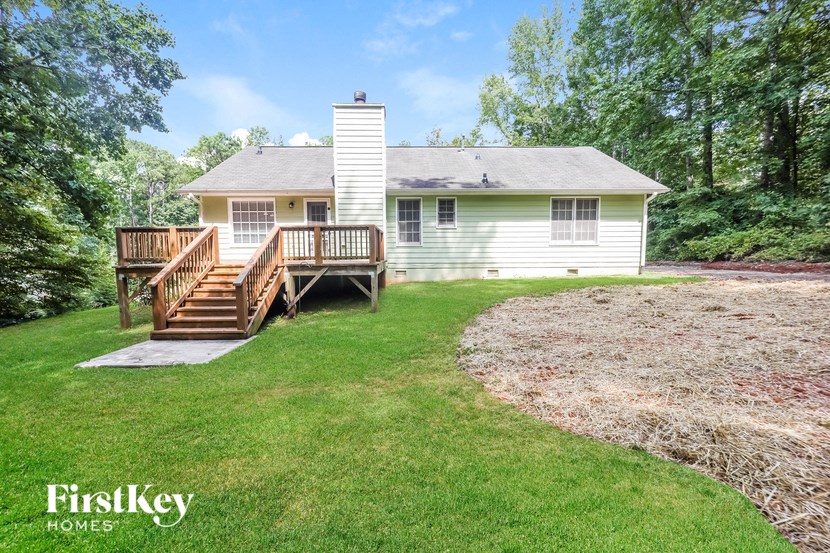 a small white house with a backyard and a deck