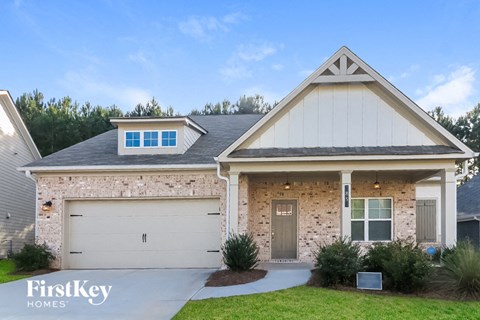 a brick house with a gray door and a white garage door