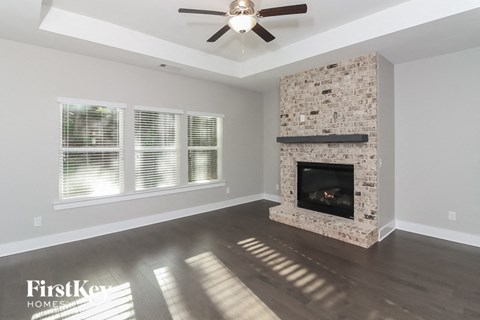 a living room with a fireplace and a ceiling fan