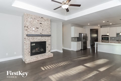 a living room with a fireplace and a kitchen