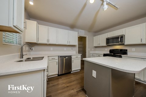 A kitchen with white cabinets and a stainless steel dishwasher.