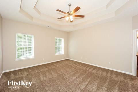 a living room with carpet and a ceiling fan
