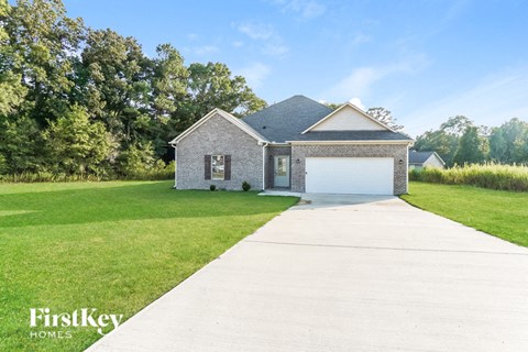 a brick house with a white garage door and a lawn