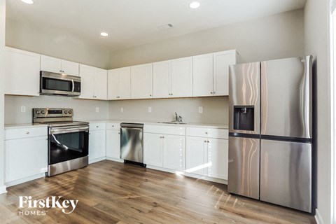 a kitchen with white cabinets and stainless steel appliances
