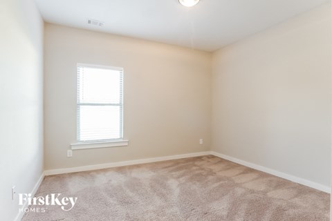 a bedroom with a carpeted floor and a window