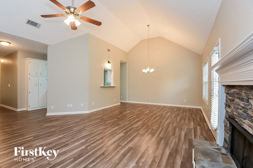 a living room with wood floors and a ceiling fan