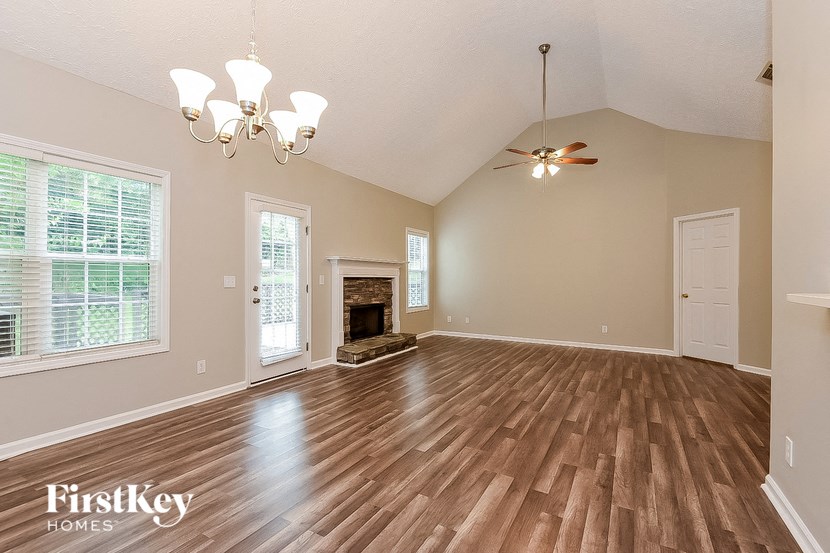an empty living room with wood floors and a fireplace