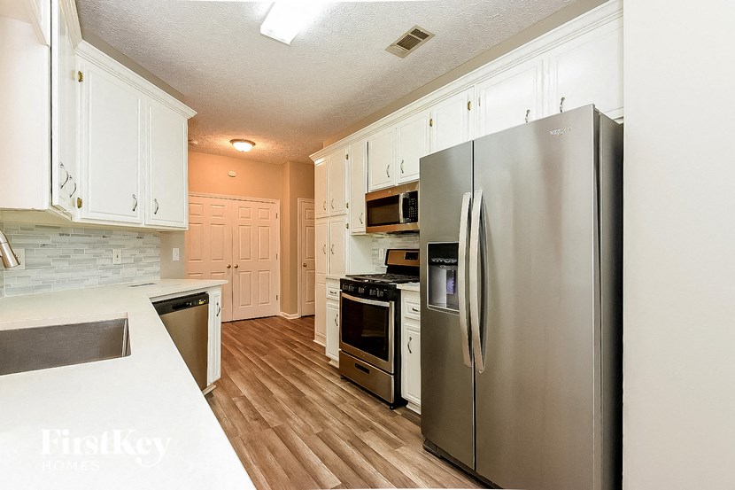 a kitchen with stainless steel appliances and white cabinets