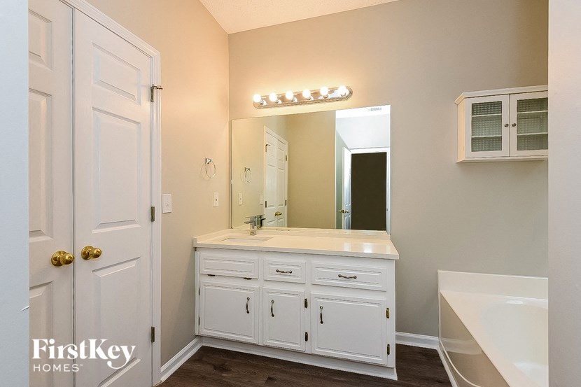 a bathroom with white cabinets and a sink and a mirror