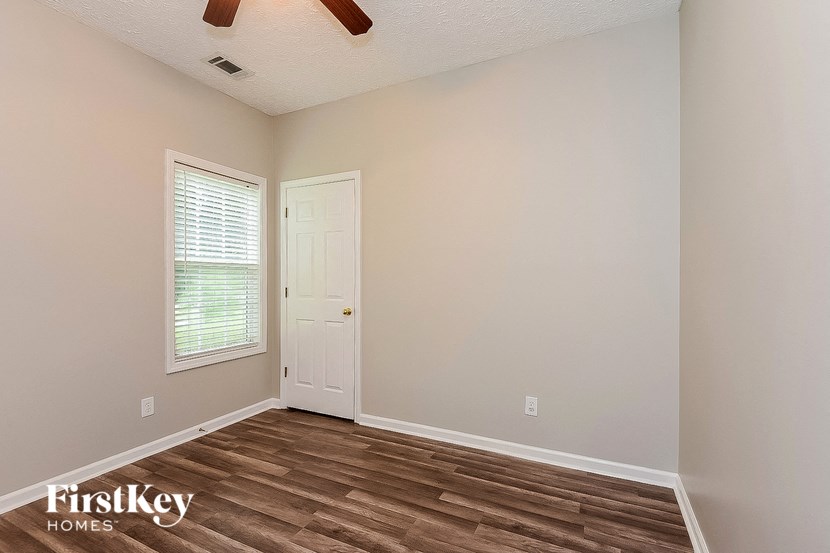 the living room of a home with a wooden floor and a white door