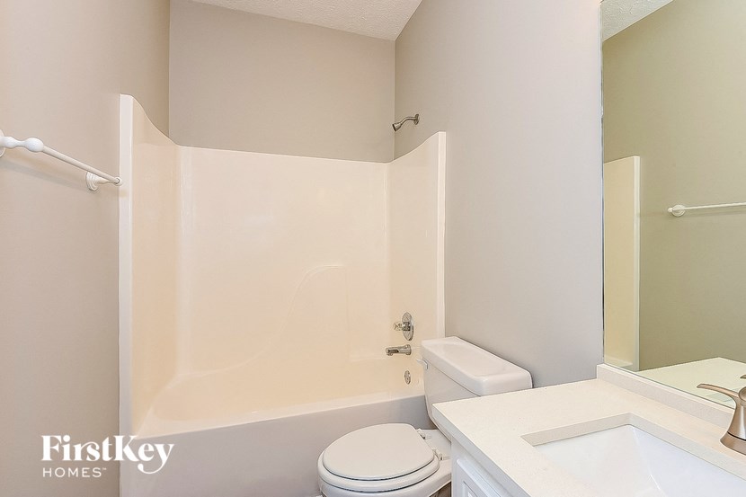a bathroom with a toilet and a tub and a sink