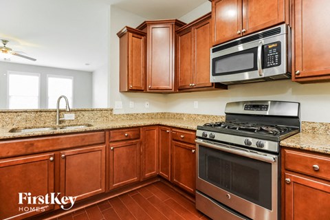 A kitchen with brown cabinets and a stove top oven.