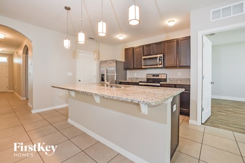 A kitchen with a counter top and a microwave.