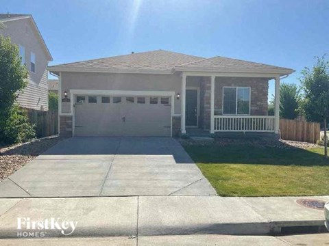 A house with a garage and a driveway in front of it.