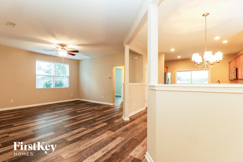the living room and dining room with the kitchen in the background