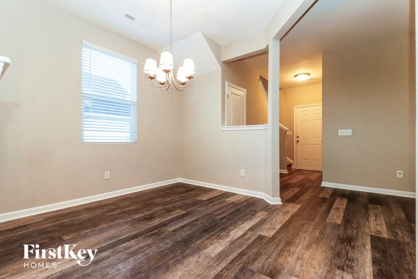the living room and dining room of a house with wood flooring