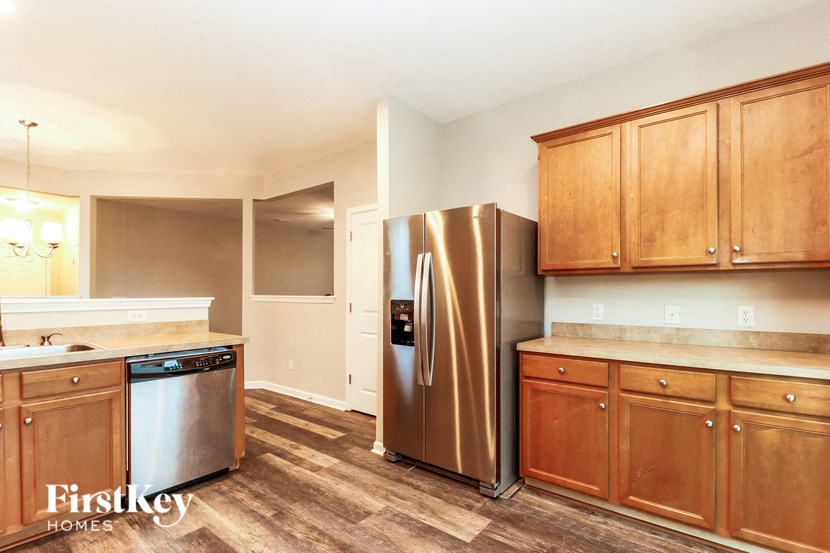 a kitchen with wooden cabinets and a stainless steel refrigerator