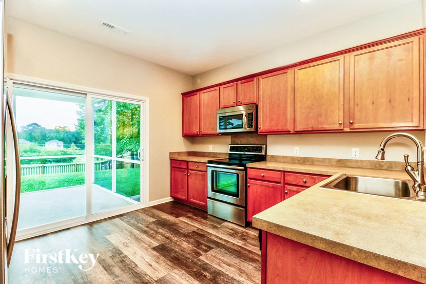 a kitchen with wooden cabinets and stainless steel appliances and a sliding glass door