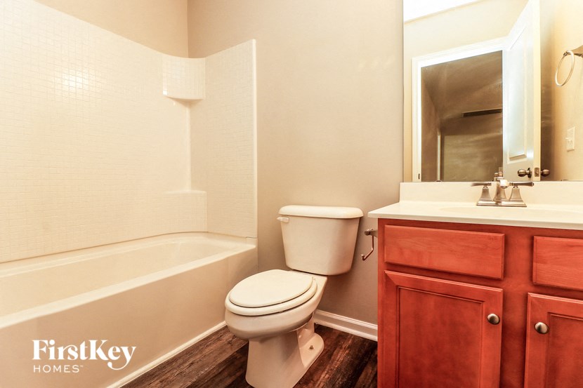 a bathroom with a toilet and a sink and a bath tub