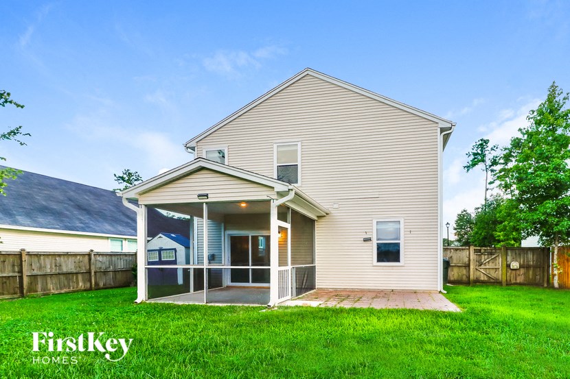 the back of a house with a porch and a lawn