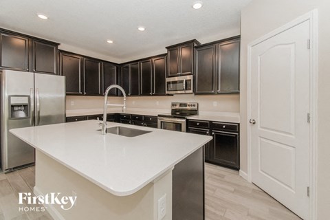 A kitchen with a white countertop and stainless steel appliances.