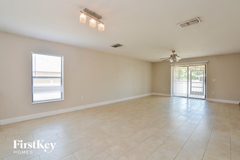 A spacious room with a sliding glass door and a ceiling fan.