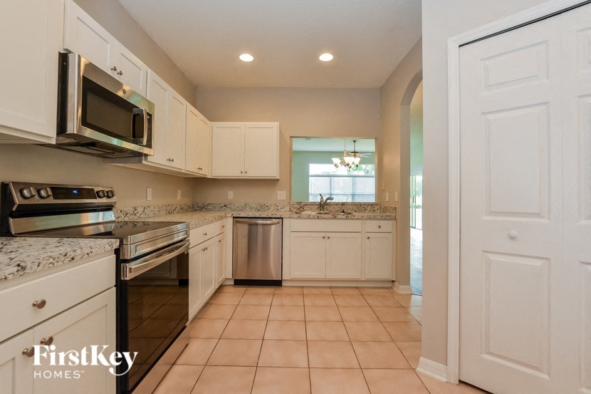 A kitchen with white cabinets and appliances.