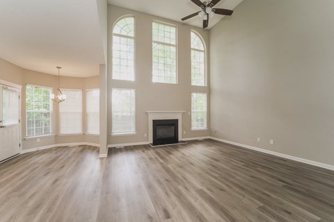 A living room with a fireplace and a ceiling fan.