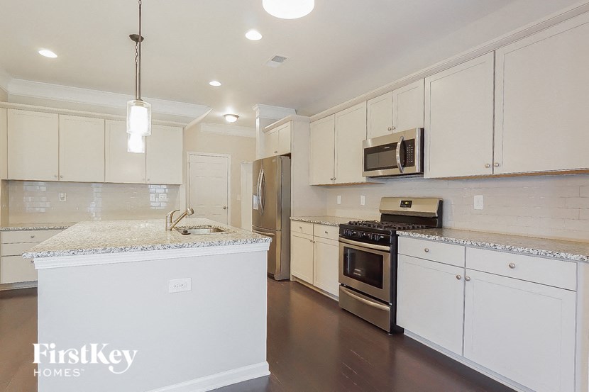 a kitchen with white cabinets and stainless steel appliances