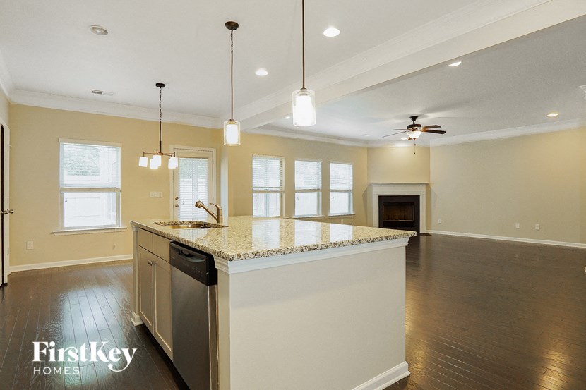 a kitchen with an island and a living room with a fireplace