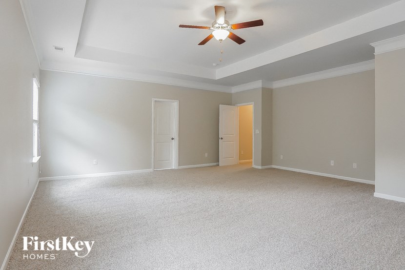 a empty living room with a ceiling fan