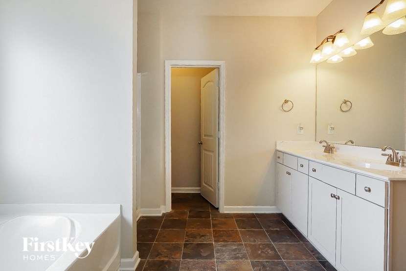 a bathroom with two sinks and a tub and a mirror