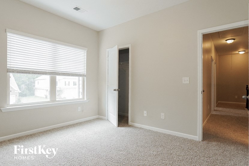 a bedroom with a door to a hallway and a large window