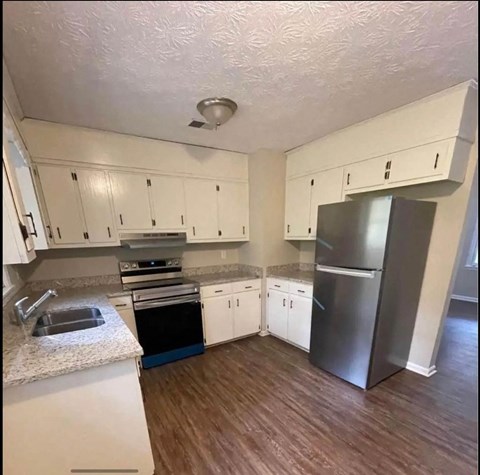 a kitchen with white cabinets and a stainless steel refrigerator