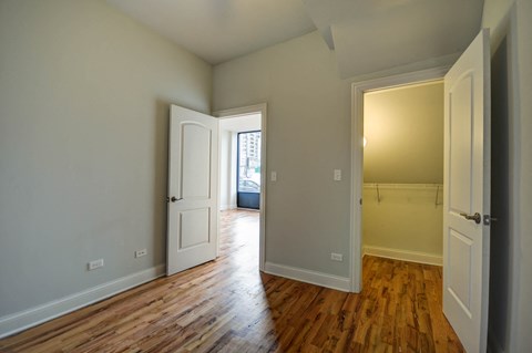 an empty living room with wood floors and white doors