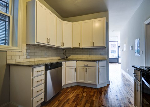 a kitchen with white cabinets and a wood floor