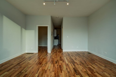 a living room with a hard wood floor and white walls