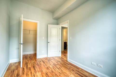 an empty room with two doors and a closet